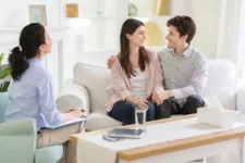 Happy couple at successful therapy session with family psychologist