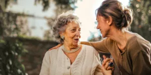 joyful adult taking care of an elderly woman