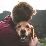 man embracing pet dog