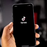 person holding an iPhone running TikTok