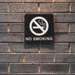 minimal shot of no smoking sign on brick wall